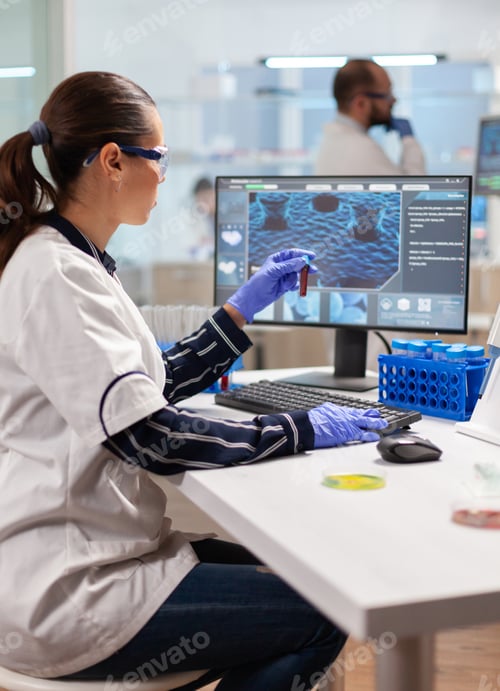 Preview: Pharmaceutical chemist looking at test tube with blood