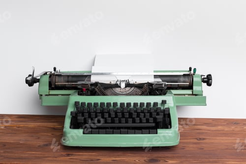 Preview: Vintage green typewriter on wooden desk with blank sheet ready for writing