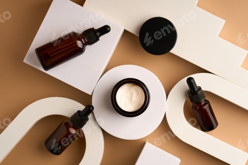 Preview: Set of beauty products in glass bottles on white podiums on beige background. Skin care set fo