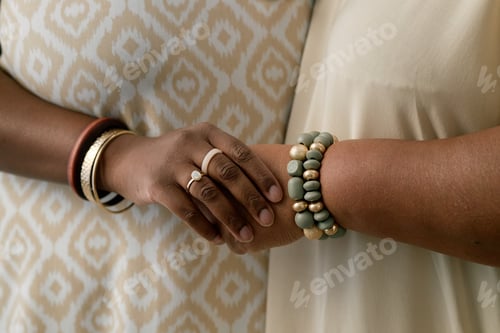 Visualização: Close Up of Black Women Wearing Bracelets Holding Hands