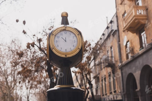 Preview: Retro urban business street clock in city center near old building - time saving and fast paced life