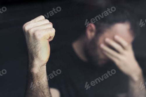 Preview: selective focus of depressed man with hand on face holding hand in fist