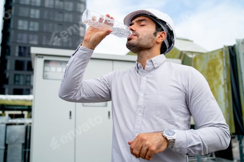 Preview: Engineer man or technician worker drink water from bottle and stand in front of electrical panel
