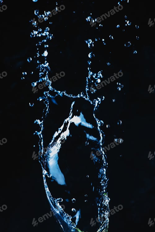 Preview: Dynamic splash of water on a dark background. Flying transparent liquid with a shiny surface. High