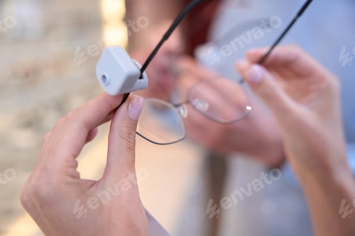 Preview: unrecognized woman is choosing the perfect optician frame in the shop