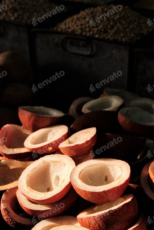 Preview: Coconuts in vegetable market in street lit by sun in India