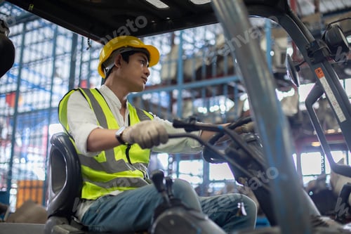 Preview: Man wear safety helmet driver forklift warehouse in factory. Male worker industrial operate.
