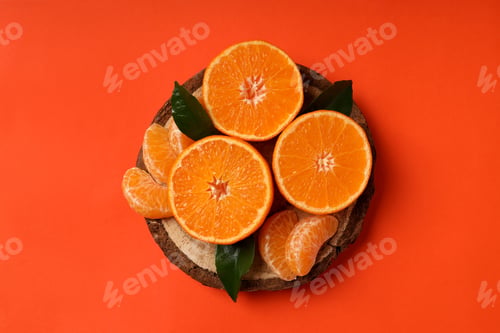 Preview: Board with mandarin and leaves on orange background