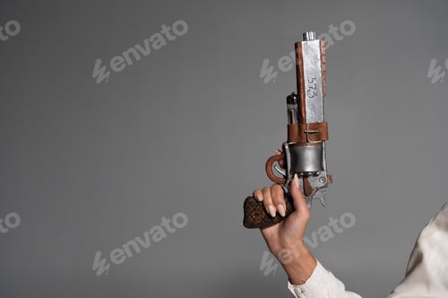 Preview: cropped view of woman holding vintage pistol isolated on grey