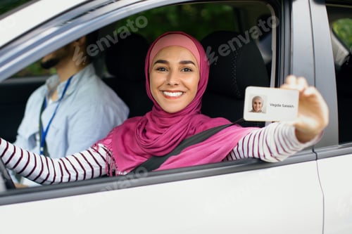 Preview: Joyful Islamic Lady In Hijab Demonstrating Driver Licence At Camera
