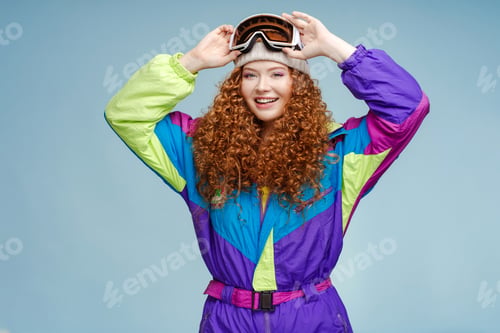 Preview: Portrait of attractive smiling curly haired woman wearing hat and protective ski goggles