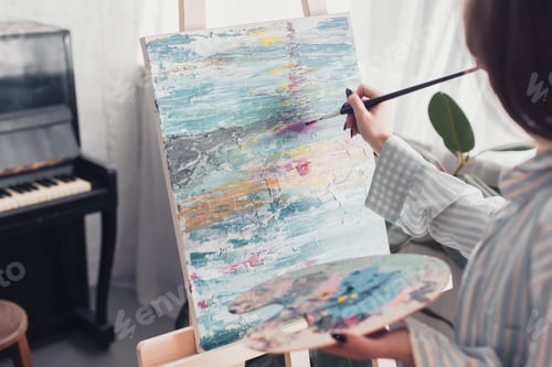 Preview: artist holding palette and painting on canvas at home