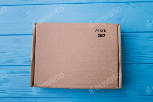 Preview: Closed cardboard box on blue wood.