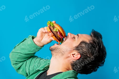 Preview: White guy in green shirt with hamburger on blue background