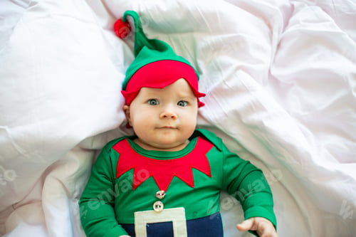 Preview: Cute caucasian baby girl six months old wearing elf costume green color.