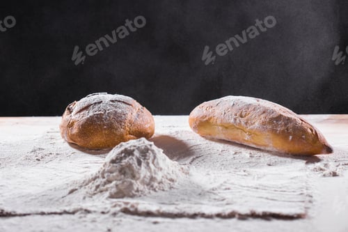 Preview: Fresh bread on table close-up in flour placer. Fresh bread on the kitchen table. The healthy eating