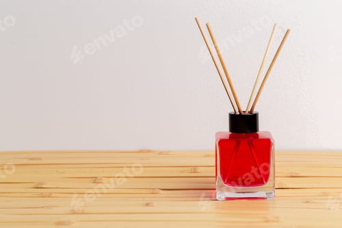 Preview: Red scented oil diffuser on wooden table with bamboo texture
