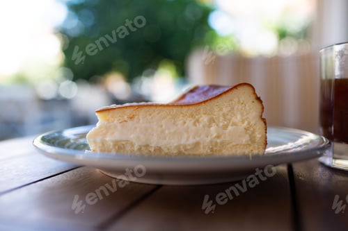 Preview: Cheescake San Sebastian slice on dish at cafe table