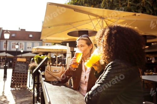Preview: Two women having drinks in sidewalk cafe