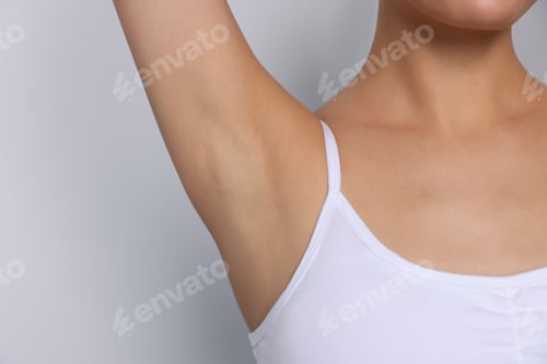 Preview: Young woman showing smooth skin after epilation on white background, closeup