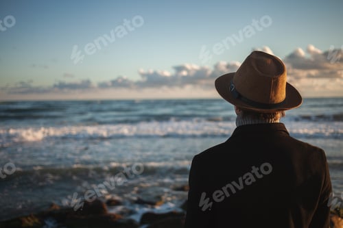 Preview: Seaside serenity lone figure takes sunset shoreline walk.