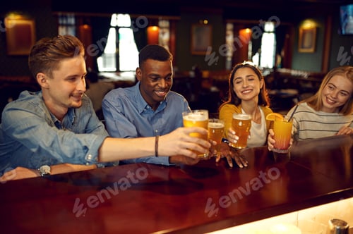 Preview: Cheerful friends drinks beer at the counter in bar