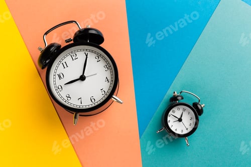 Preview: Vintage black alarm clock on a color block background
