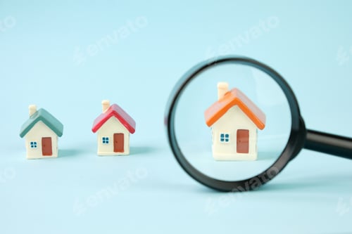 Preview: Small houses under a magnifying glass. Real estate search concept, purchase and sale of housing