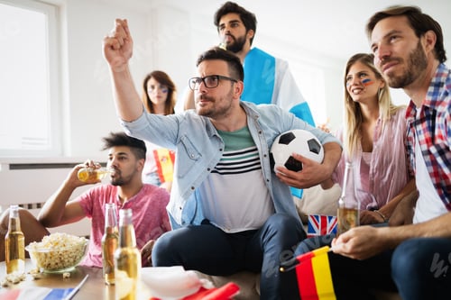 Preview: Soccer fans emotionally watching game in the living room.