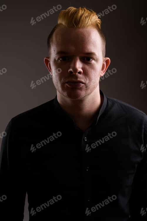 Preview: Businessman with Mohawk hairstyle and blond hair against gray ba
