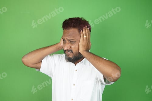 Preview: Indian adult man get nervous with his hands up on the green background