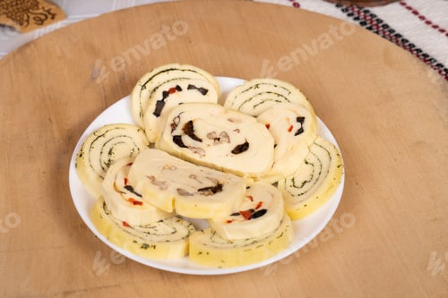 Preview: Closeup of a plate with cheese roll-ups on the wooden tray.