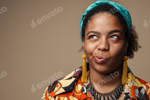 Preview: Young black woman in headband grimacing and looking upward