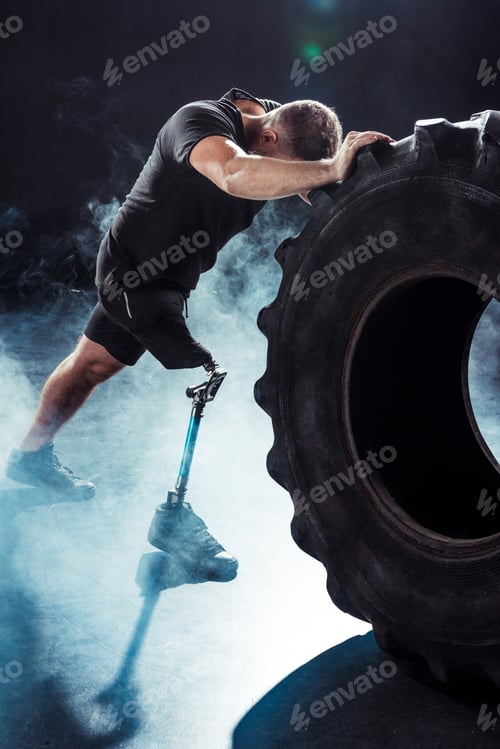 Preview: partial view of paralympic sportsman with leg prosthesis pulling tire