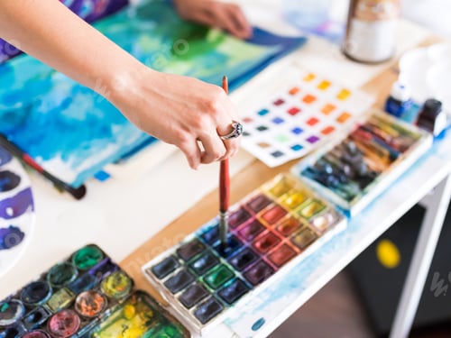 Preview: Close up hand dipping brush in palette