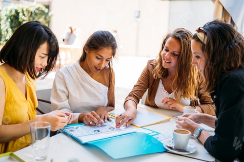 Preview: University exchange students planning and studying together at a cafe