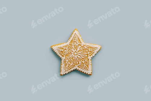 Preview: Christmas gingerbread snowflake with white glaze ornament on a blue background