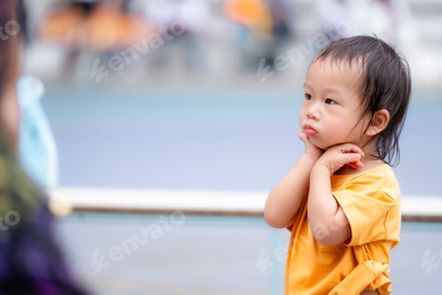 Preview: Little One, Big Thoughts, Asian young child boy in a vibrant yellow shirt.