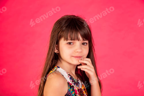 Preview: Charming Child Model Showcases Playful Expression Against Vibrant Pink Background