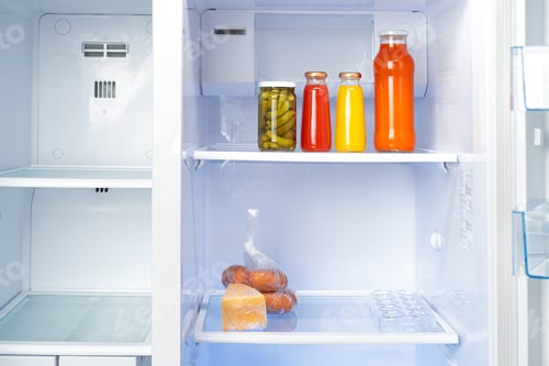 Preview: Glass jars of canned products on a fridge shelf