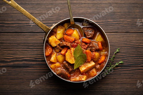 Preview: Delicious stew with meat, potatoes, carrot and gravy in rustic copper pot