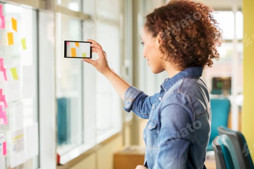 Preview: Female digital designer photographing adhesive notes on office wall