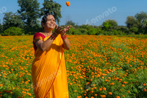 Preview: Indian woman in marigold field and enjoying nature.