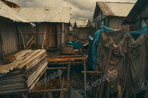 Preview: Wooden houses on stilts over Lake Tadane against a cloudy sky in Nzulenzu village, Ghana
