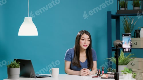 Preview: Female blogger recording makeup tutorial on camera in studio