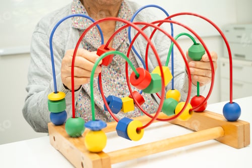 Preview: Asian elderly woman playing enhancing skill board game.
