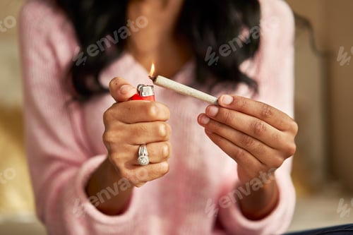Preview: close up of african american woman lighting marijuana joint at home