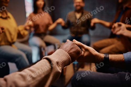 Preview: Close up of people holding hands during group therapy at mental health center.