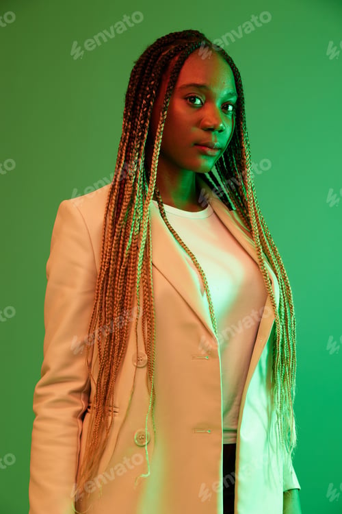 Preview: African american woman portrait business smile on green background in neon light, color mixed light