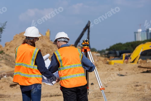 Preview: Two construction surveyors planning and discussing land measurement for infrastructure development.